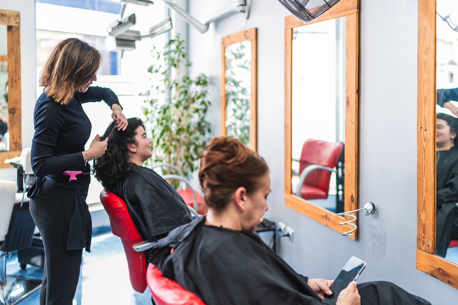 Clients enjoying hair services in a cozy and spacious Duluth rental
  beauty salon shop.